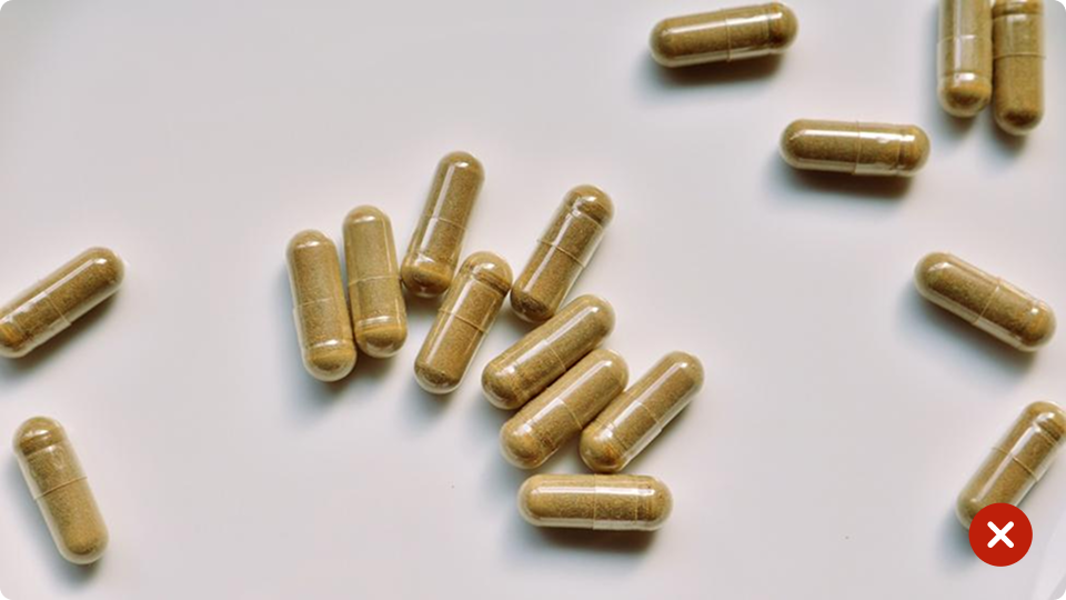 Brown capsules scattered on a white surface 